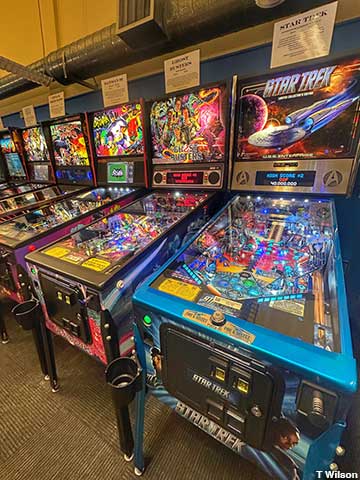 Pinball machines with vital stats and history labels.