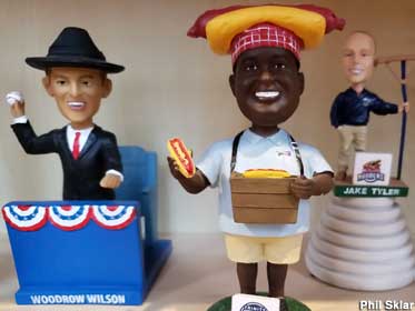 Bobbleheads of a man with a giant hot dog on his head, President Woodrow Wilson, and a groundskeeper.
